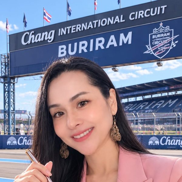 Natalie in a pink blazer, smiling and holding a pen, at Chang International Circuit, Buriram